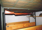 2015 07 19 6624  Spodní část dvoupatrových postelí se zavěšenou puškou.